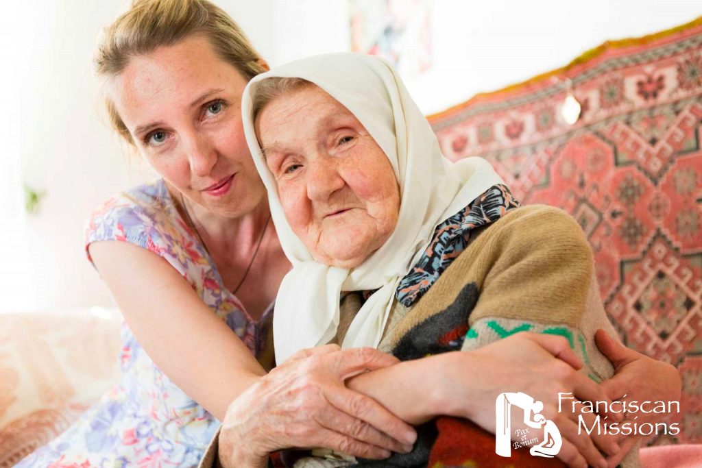 A young woman embraces an elderly woman in Ukraine.