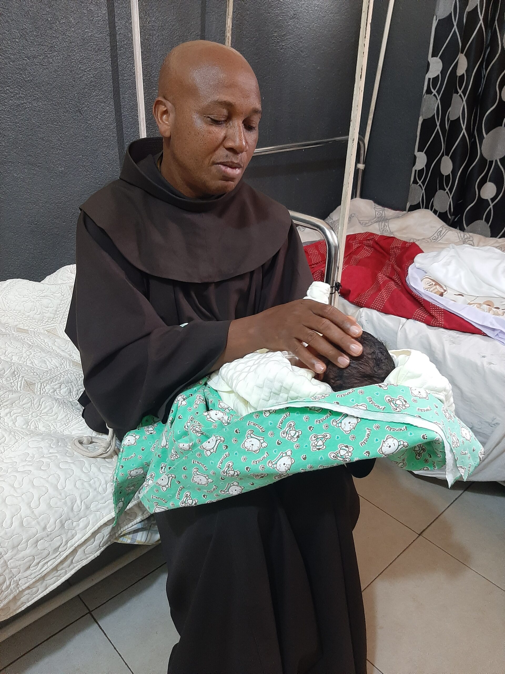 Fr. Hrmenegilde Birushe – Burundi – Construction of a dispensary Fr. Hrmenegilde Birushe holding a newborn child in the Burundi dispensary