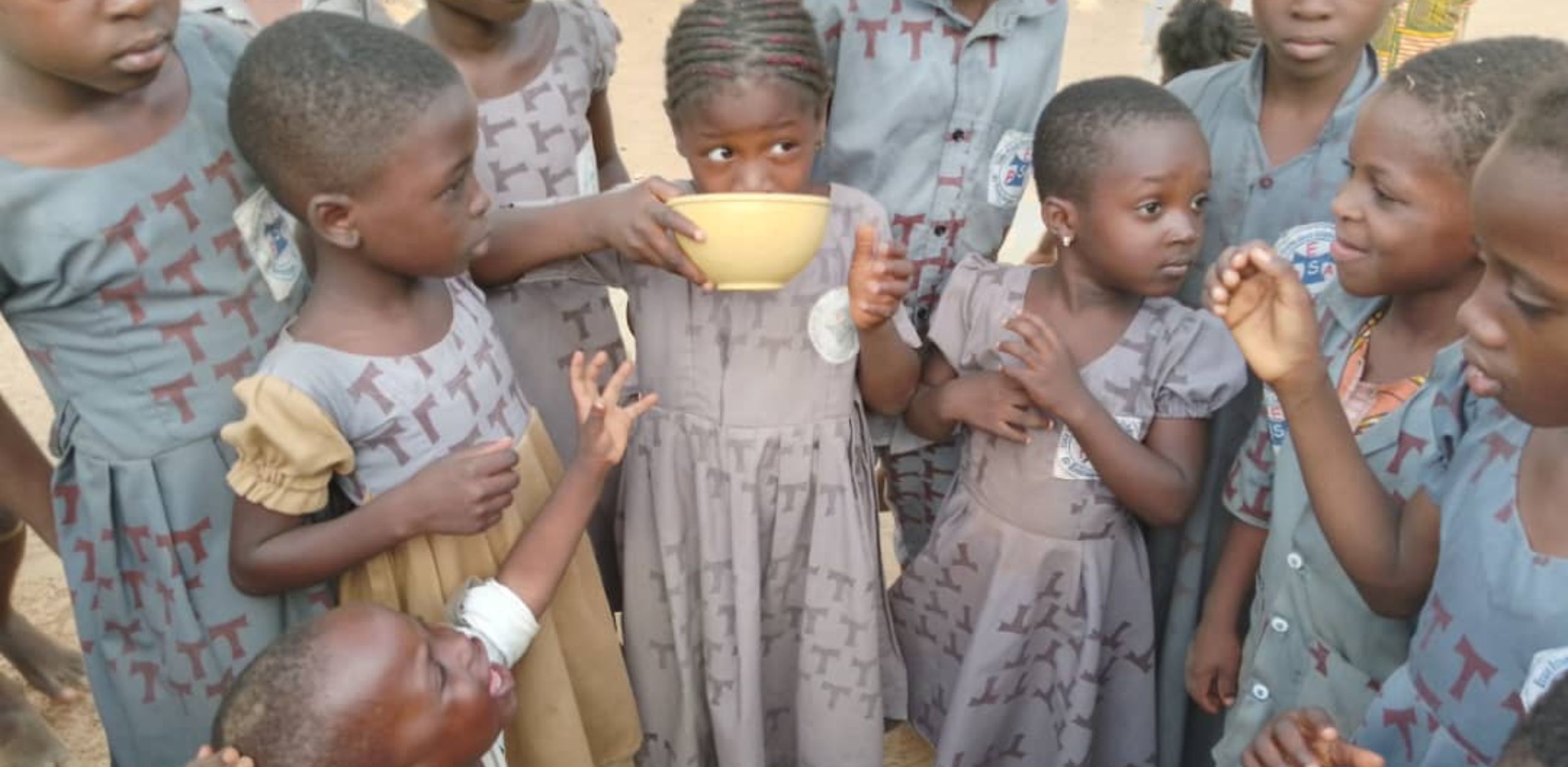 children in Africa drinking water in bowls